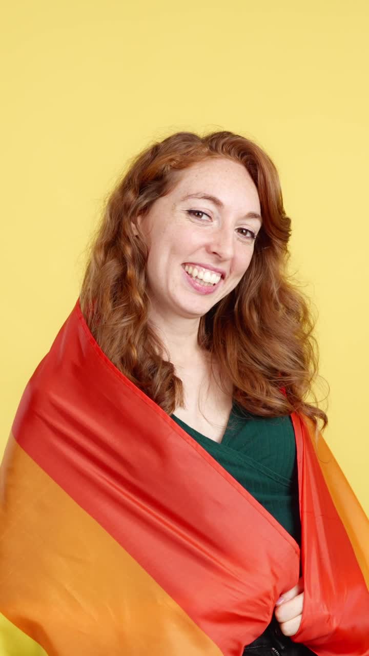 Smiling Woman Wrapped in Rainbow Flag
