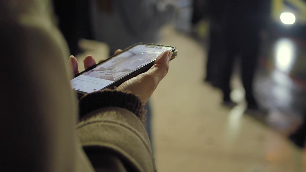 Close-up of a Person Holding a Smartphone and Scrolling Through Content at Night