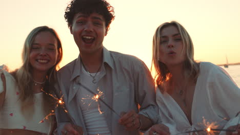 amigos celebrando el atardecer junto al lago con sparkler