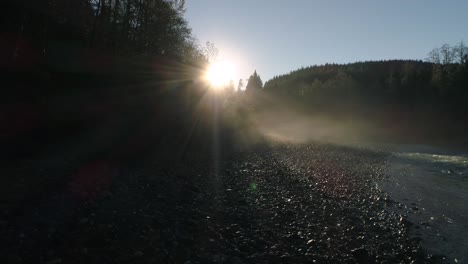 dolly across forest river sunrise in early morning lowland fog haze