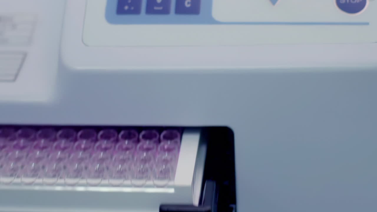 Researcher or scientific putting 96 well micro plate into plate reader quantitative PCR machine to measure and analyze DNA or RNA quantification in a biotechnology laboratory