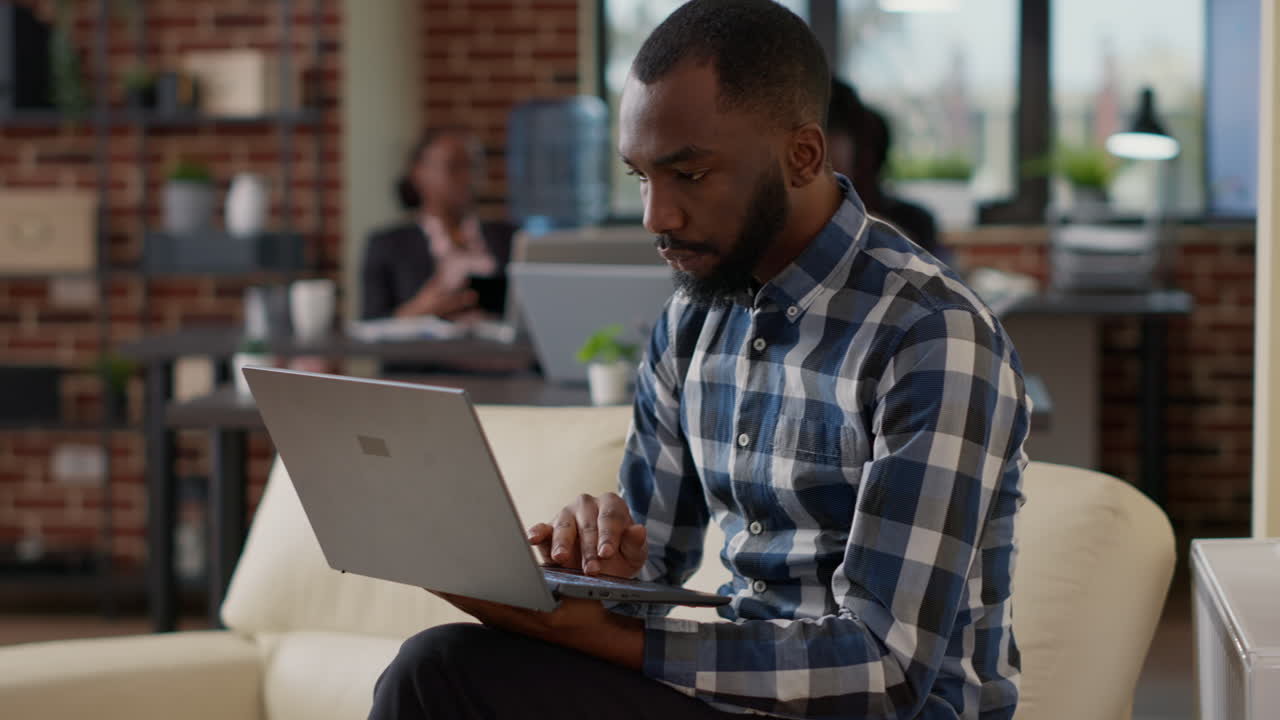 African american worker analyzing financial report on laptop