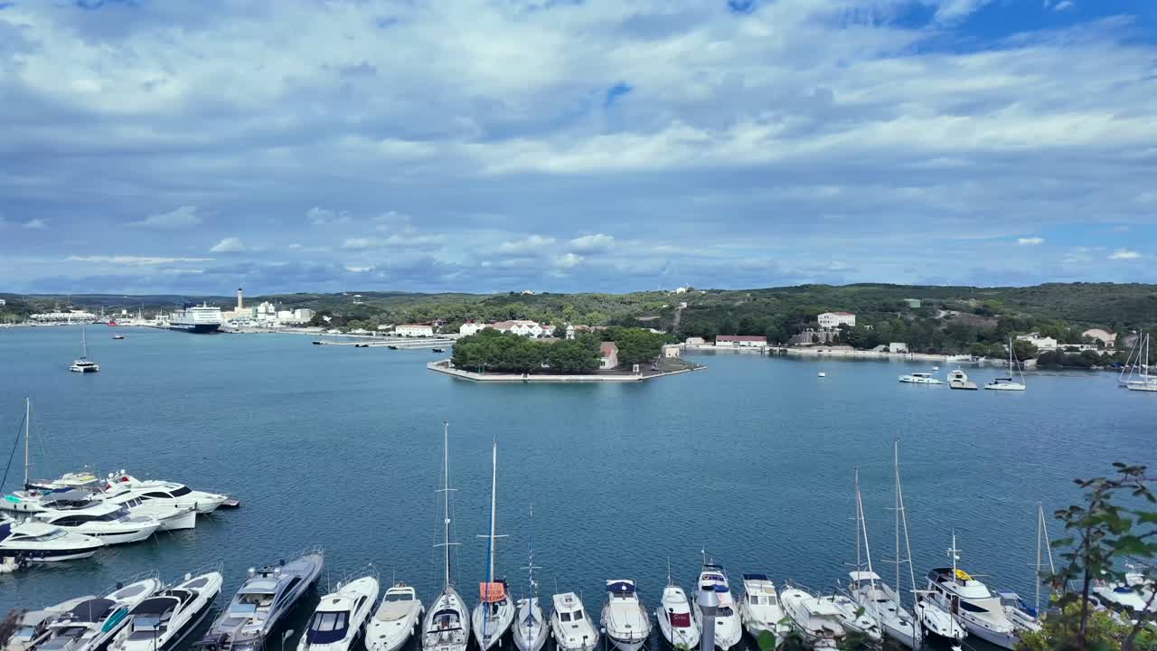 Timelase of Mahon Bay (Menorca Island). Elevated perspective of the marine with moving boats in a quiet summer day