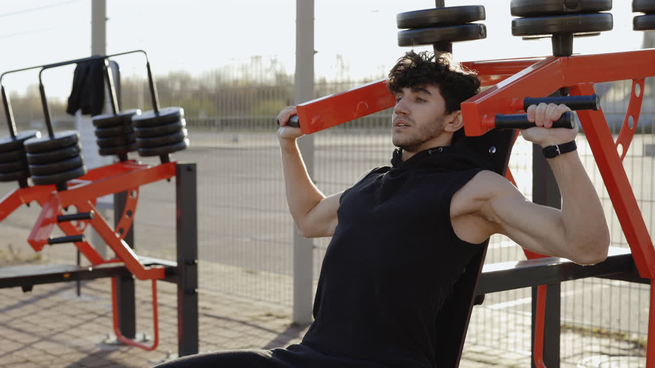 Man doing shoulder press at outdoor gym