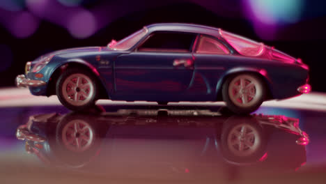 blue model car with reflective surface and bokeh lights
