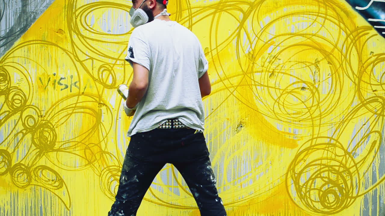 L'artista realizza graffiti su una recinzione. Disegno astratto