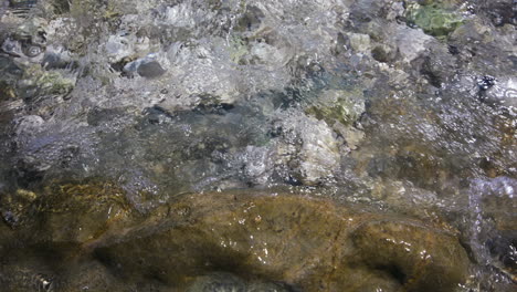 rocks on beach and adriatic sea waves, close up detail