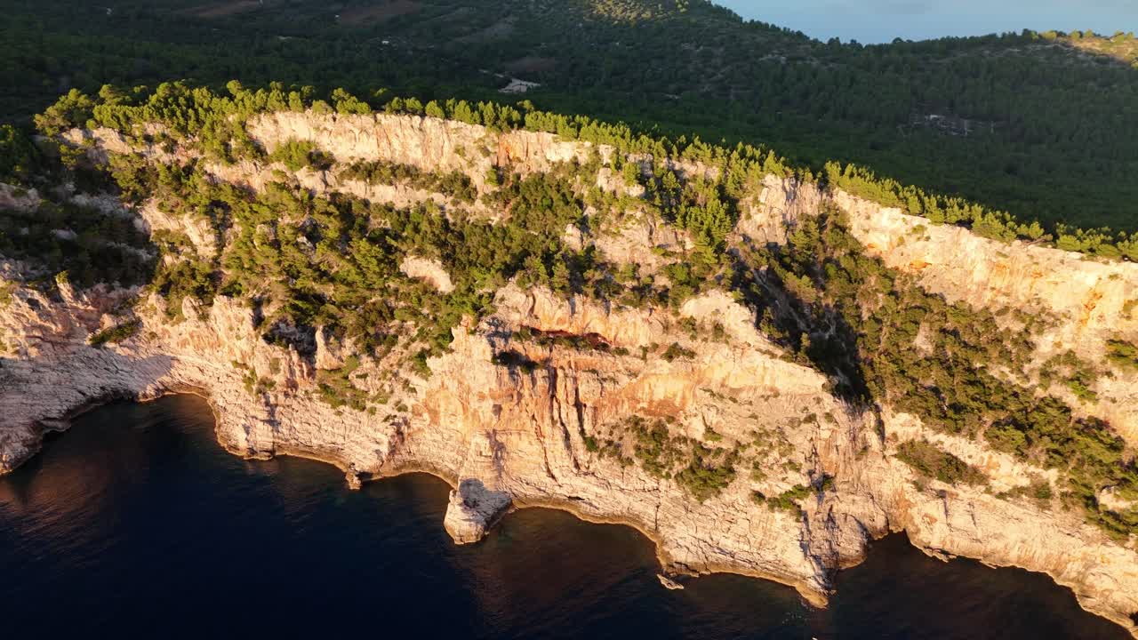 Drone flight along Telascica cliffs on Dugi Otok, golden light above the dark Adriatic sea, revealing Croatia’s dramatic national park coastline