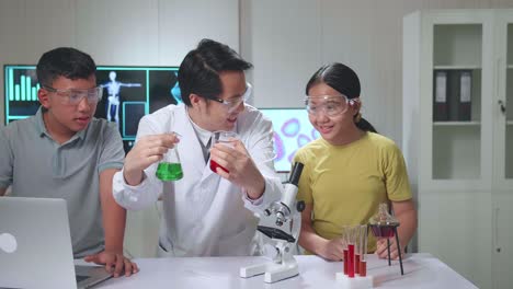 young asian boy and girl learning science experiment in laboratory with teacher in classroom. study with scientific equipment and test tubes