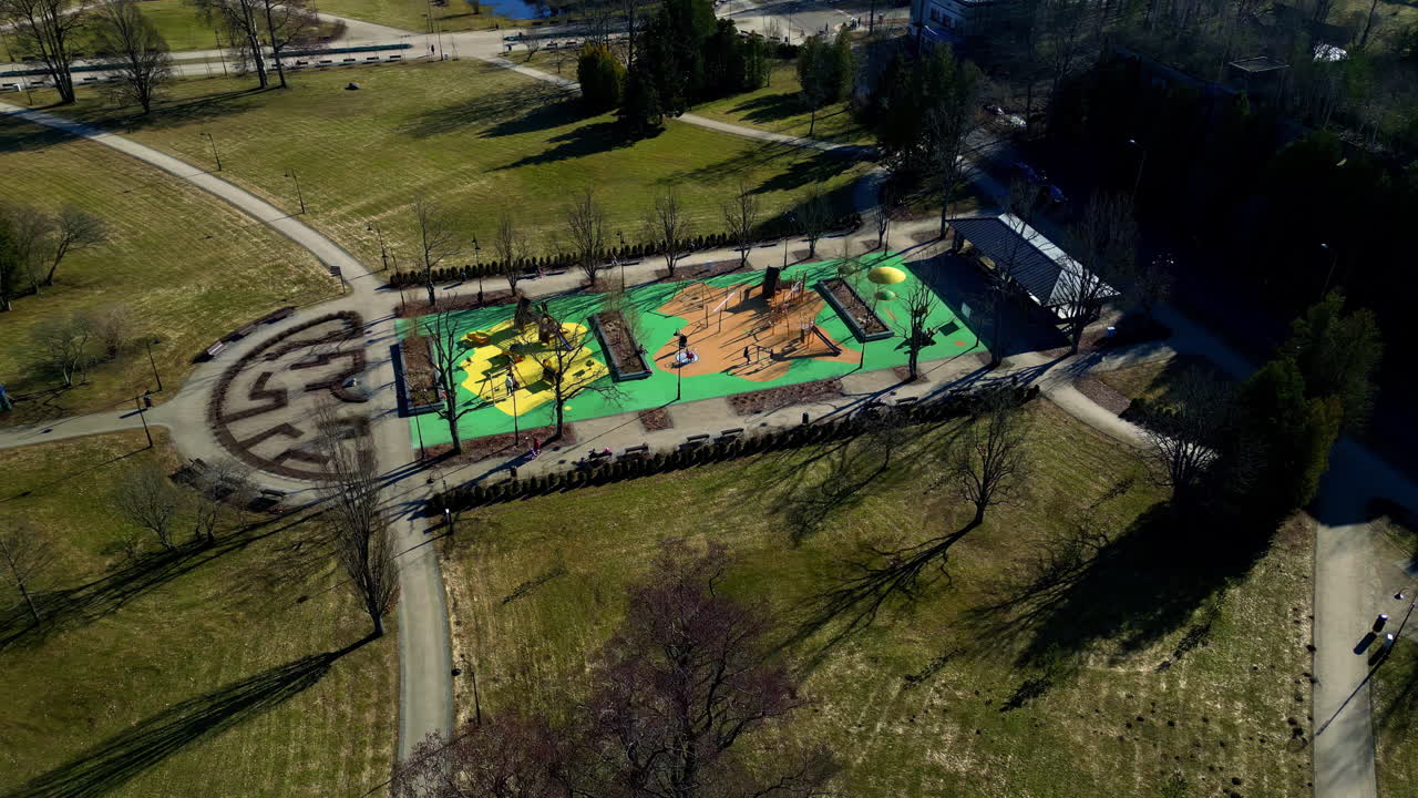 панорамный воздушный снимок с дроном, люди на игровой площадке, наслаждающиеся природой.