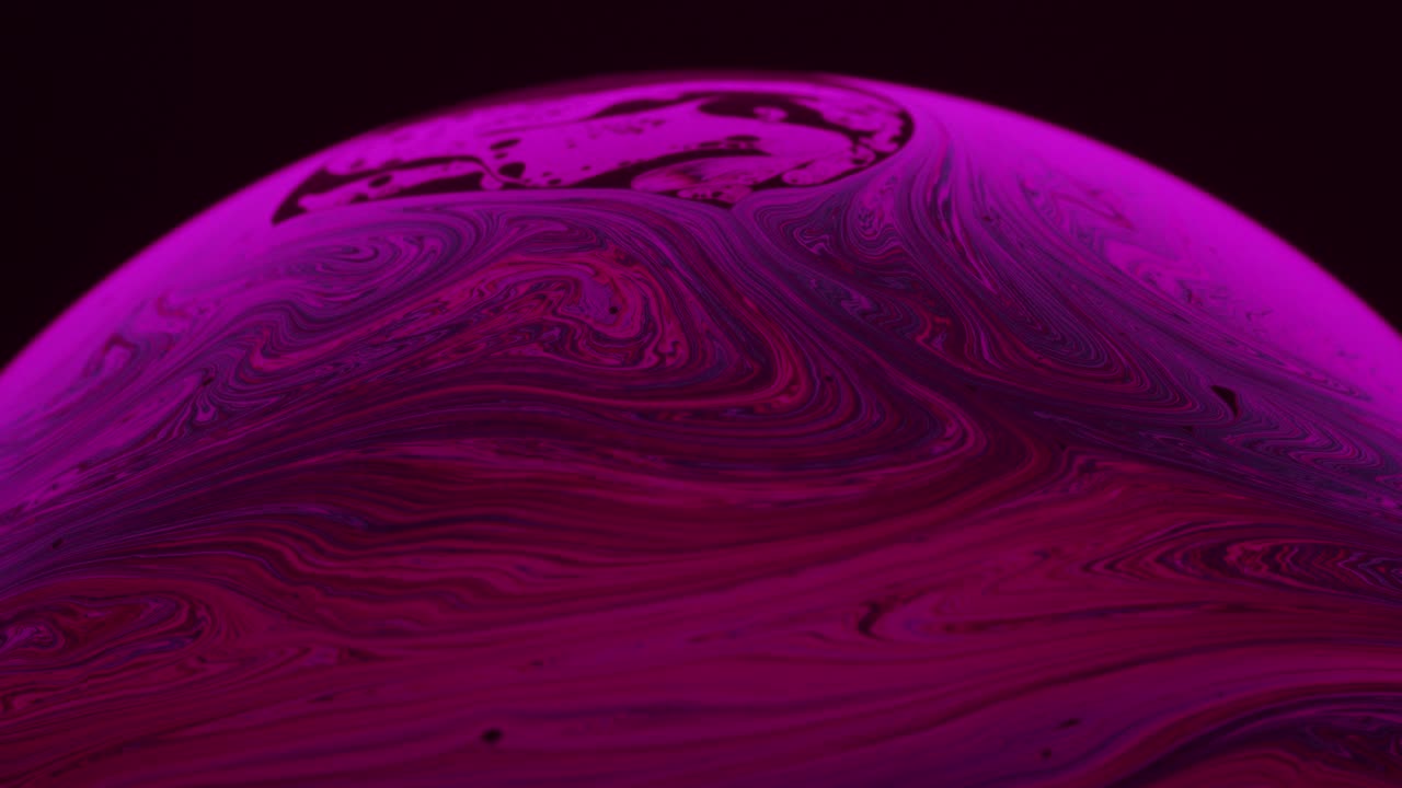 líneas rosadas girando en círculos en una solución líquida de jabón: macro abstract shot