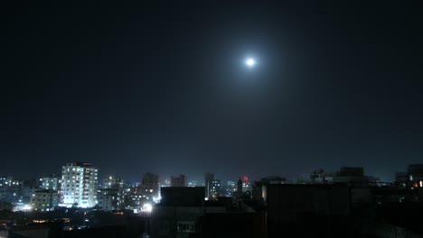 a mesmerizing timelapse of dhaka's cityscape, with the moon gradually setting over the skyline, capturing the transition from night to dawn.