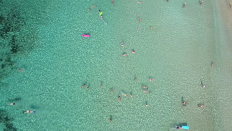 Aerial-footage-of-people-bathing-at-a-shallow-sandy-beach