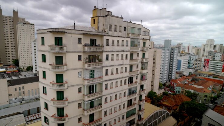 Panoramica aerea di un paesaggio urbano con vari edifici, strade e spazi verdi sotto un cielo nuvoloso, che evidenzia l'architettura urbana e le aree residenziali a San Paolo, Brasile.