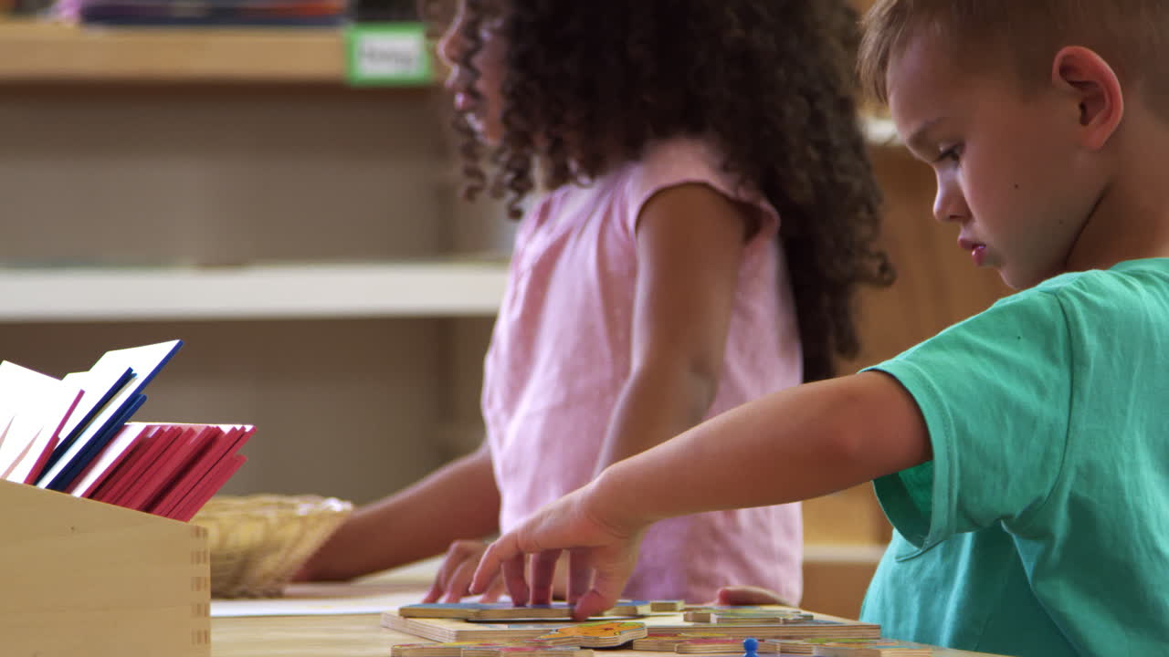 alumnos de montessori trabajando en un escritorio con rompecabezas de forma de madera