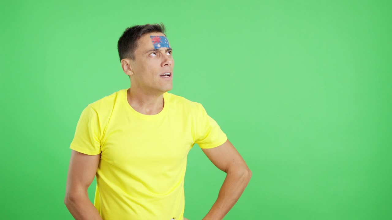 Nervous man cheering for Australia during a match looking away