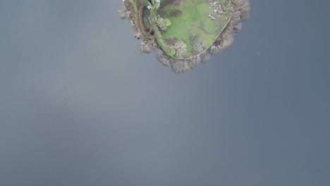 mcdermott castle on an island in lough key, county roscommon, ireland, surrounded by lush greenery and water, seen from above