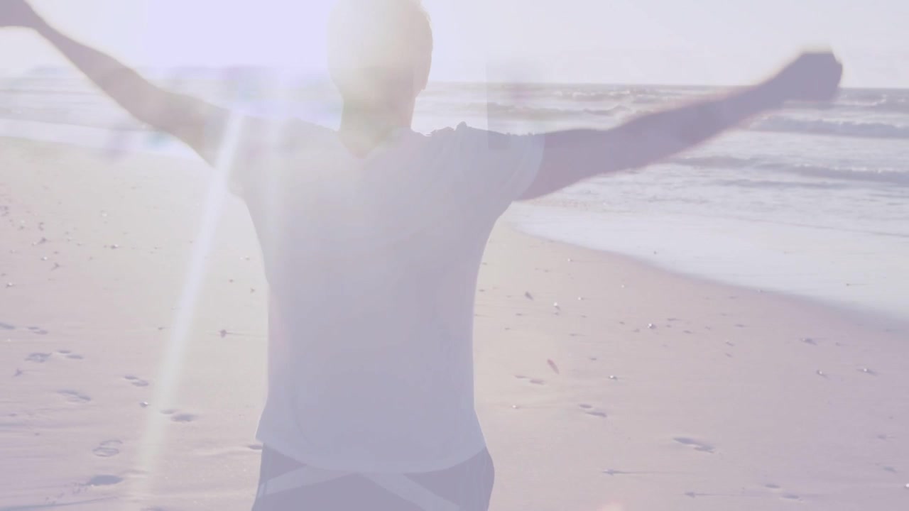 Senior man walking shore, turning to sea, stretching, running to waves with lens flare for health