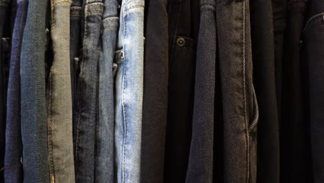 different shades and washes of jeans hanging in a store