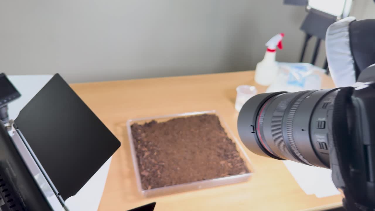 Camera setup captures soil in a studio environment with controlled lighting and macro focus