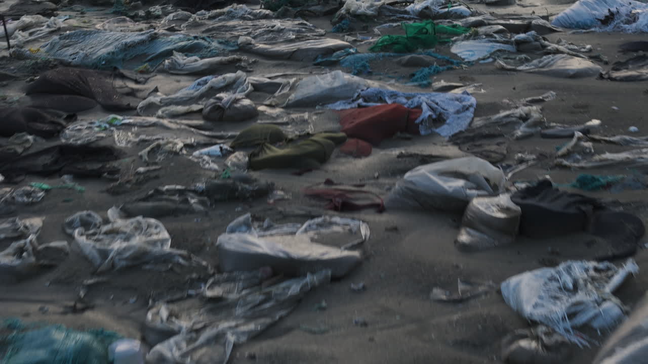 tomada de avión no tripulado que revela residuos plásticos en la orilla de la playa, contaminación del agua, residuos de moda, basura del océano con la vista de la playa bajo un cielo brumoso