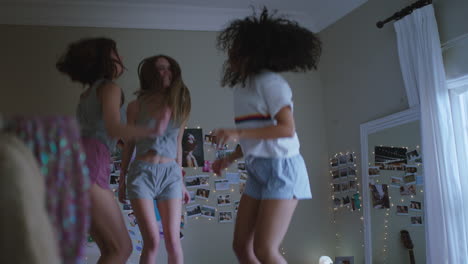 happy teenage girls jumping on bed at home best friends celebrating together enjoying vacation weekend