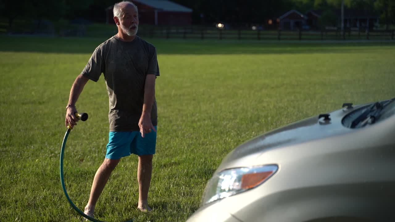 슬로우 모션으로 자동차에 살포하는 동안 치실 댄스를 하면서 세차하는 미친 남자