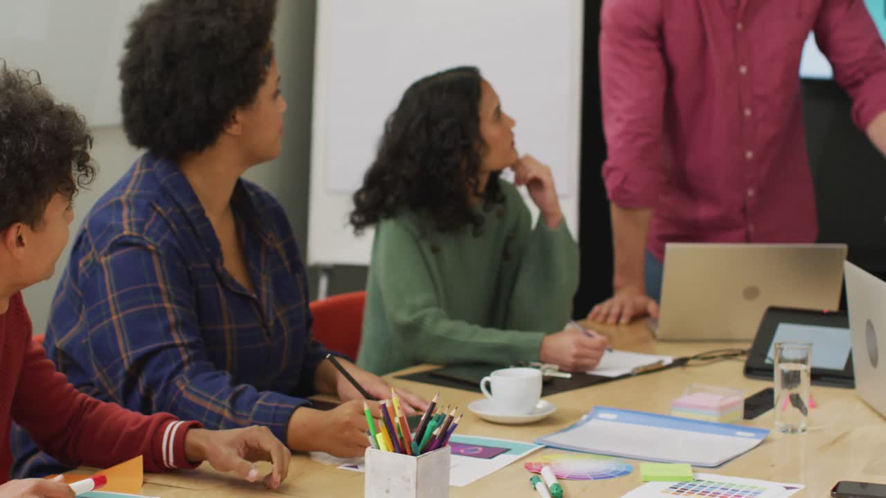 Happy diverse business people discussing work during meeting at office