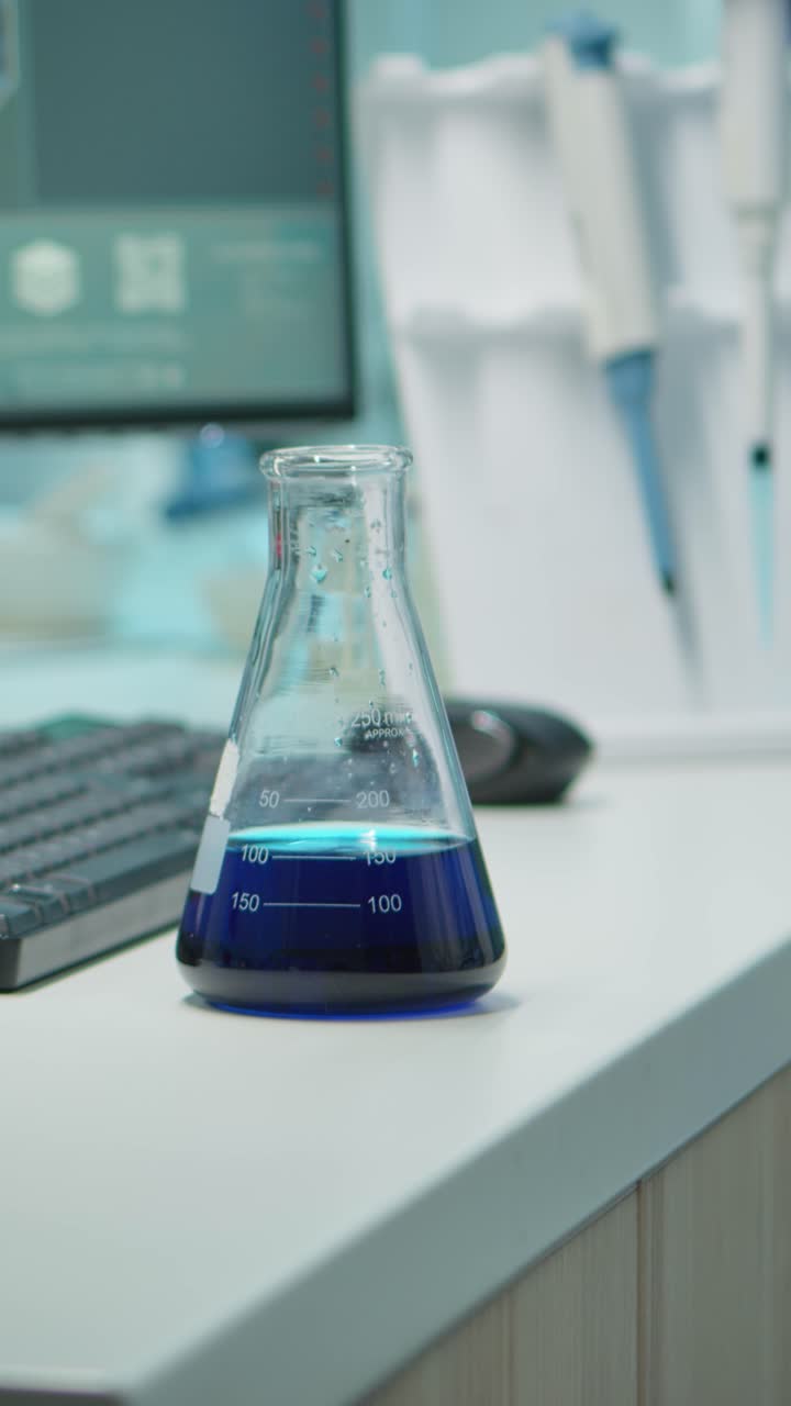 Vertical video: Close up of scientis testing liquid sample using micropipette