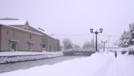 Lone-person-walking-next-to-famous-Otaru-Canal-in-Hokkaido,-Japan