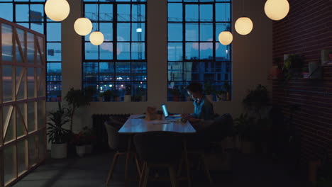 caucasian business woman working late using laptop computer typing project manager browsing online research planning deadline writing notes in office at night