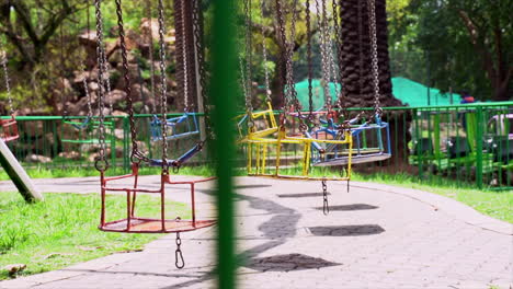 wide shot of empty swings in an amusement park