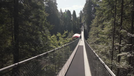 Mujer-Caminando-Sobre-Un-Puente-Colgante-Vacío-Con-Bandera-Canadiense