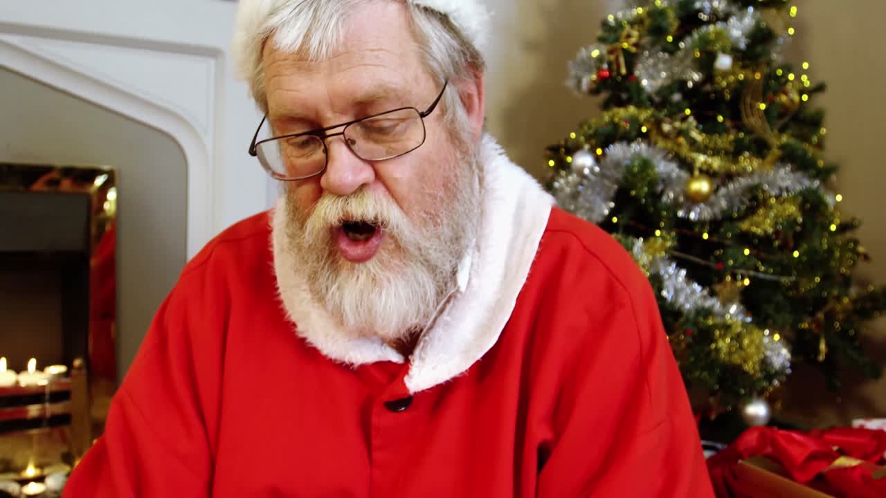 santa claus sentado cerca de la chimenea