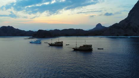 Grupo-De-Tres-Pequeños-Cruceros-Anclados-Frente-A-La-Costa-De-La-Isla-Padar-En-El-Parque-Nacional-De-Komodo-En-Indonesia