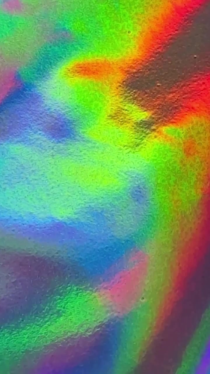 Abstraktní holografická fóliová textura měnící se se zářivými barvami