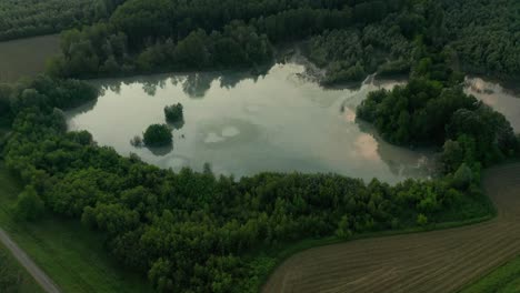 Antena-4k:-Toma-Reveladora-Cinematográfica-Rápida-De-Un-Paisaje-Campestre-Con-Un-Lago-Natural-Reflectante