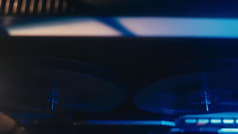 a close-up on a vintage tape recorder in a blue light