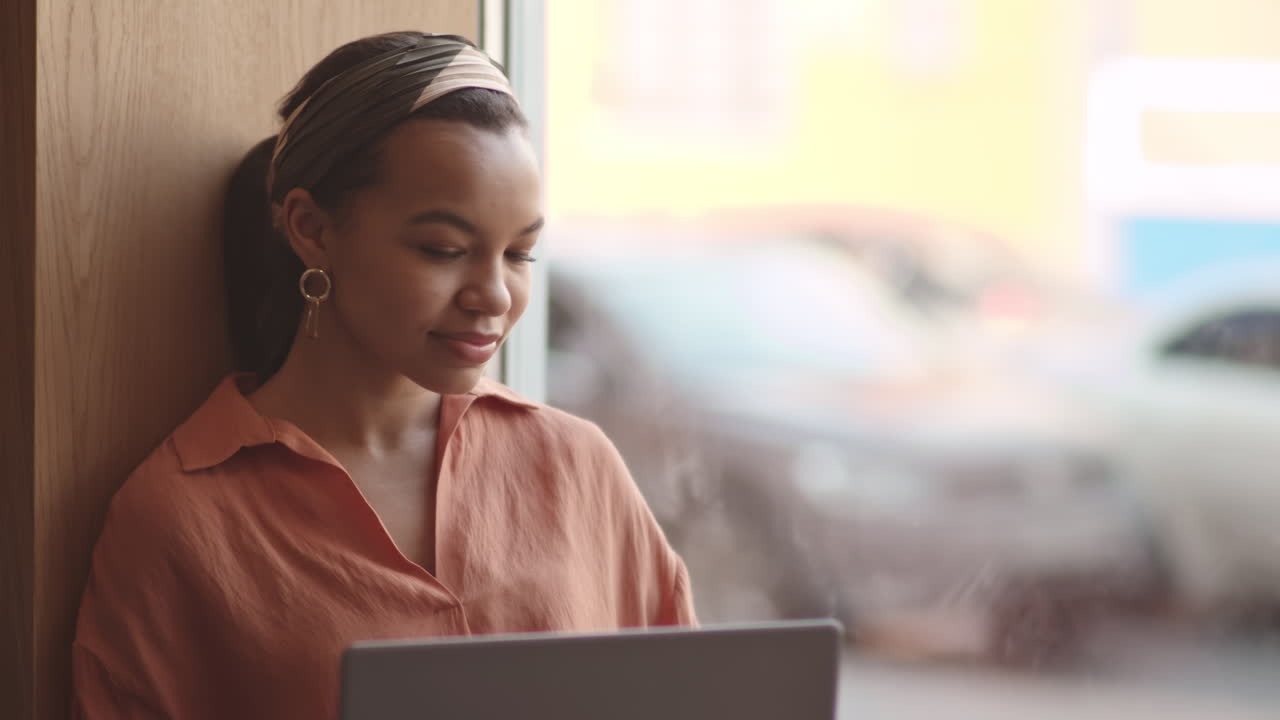 Businesswoman Working on Laptop on Windowsill