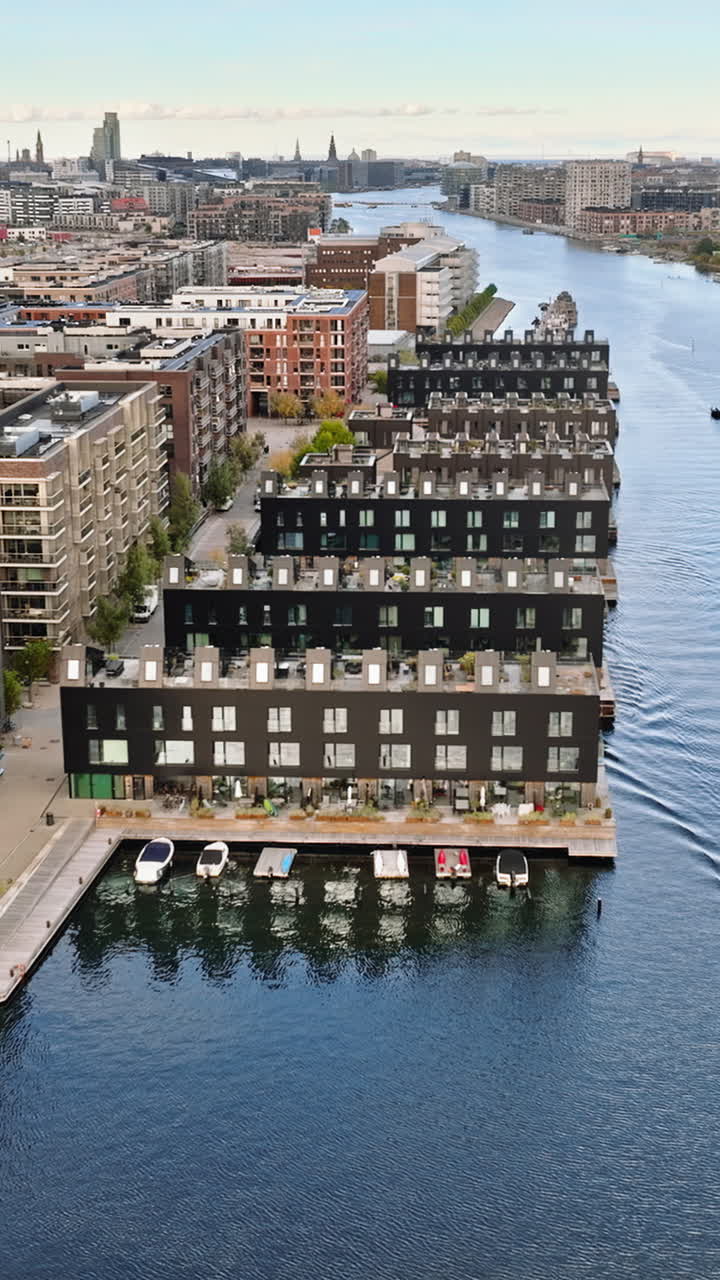 Aerial drone view of a yellow boat moving on the water in the Teglholmen peninsula in the South Harbour of Copenhagen, Denmark. Vertical