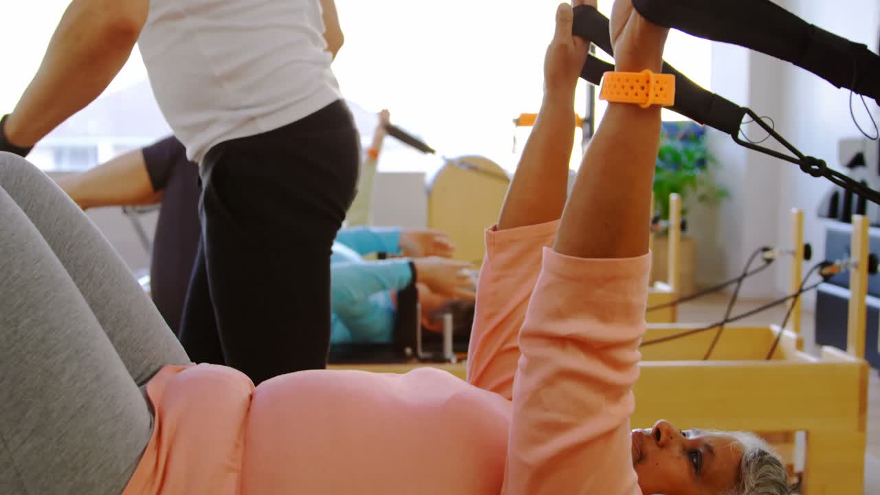 4k 운동을 하는 동안 고령 여성들을 돕는 트레이너