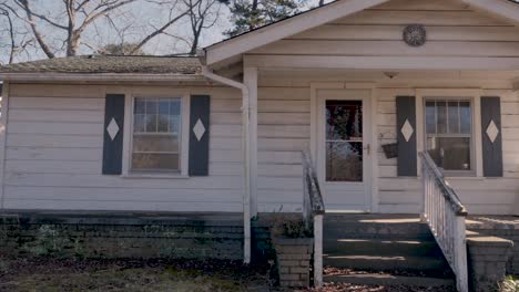 front entrance of a one story rundown empty single family home