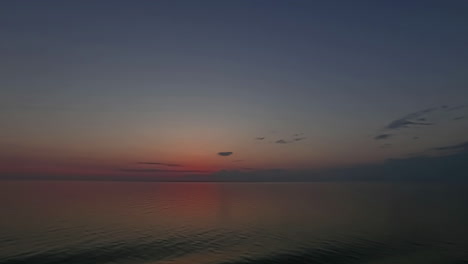 Toma-De-Tiempo-Del-Cielo-Colorido-Después-De-La-Puesta-De-Sol-Sobre-El-Agua-Del-Mar-Durante-La-Noche