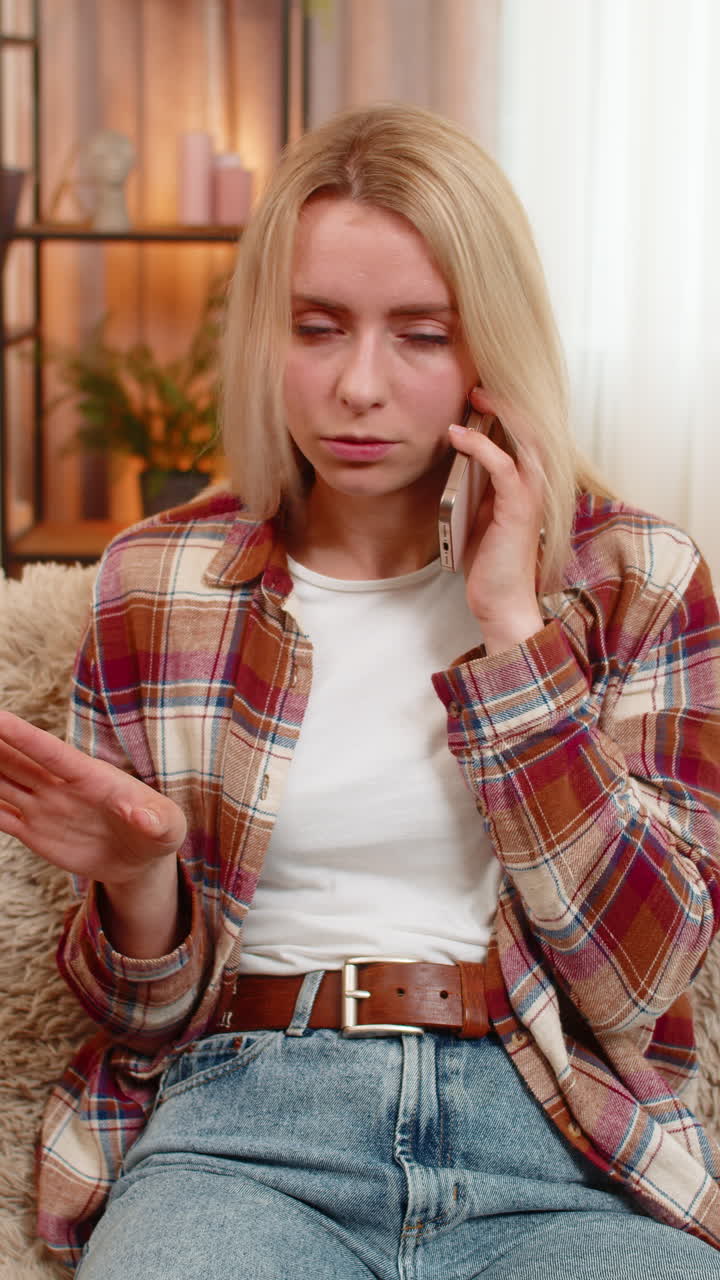 Woman rejecting call on smartphone at home showing hand gesture to say no with irritated expression