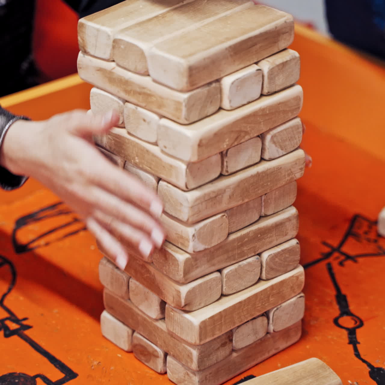 The family plays wooden tower table game together.