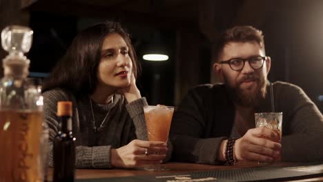 una pareja disfrutando de cócteles en un bar.