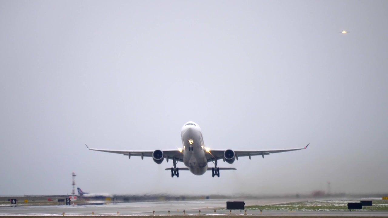 Airbus A330 in decollo dalla pista, giornata nuvolosa, vista dal basso della fusoliera.
