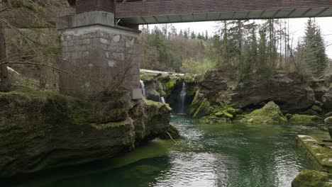 a slow cinematic shot of traunfall austria with approach under the bridge