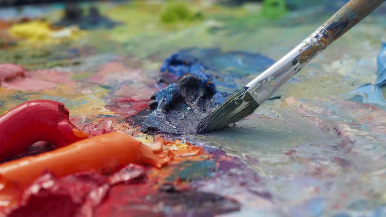 다채로운 페인트를 가진 팔레트에 페인트 브러쉬의 근접
