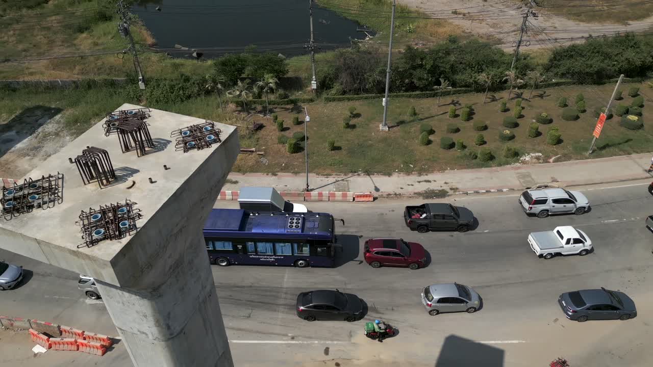 Aerial view of traffic on a road alongside elevated highway construction